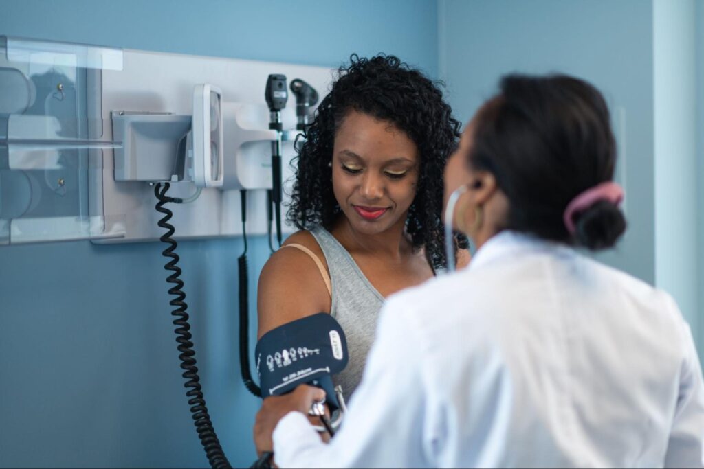 MOGA nurse checking a pregnant patient’s blood pressure with an arm cuff during a prenatal appointment in a Memphis OB/GYN exam room